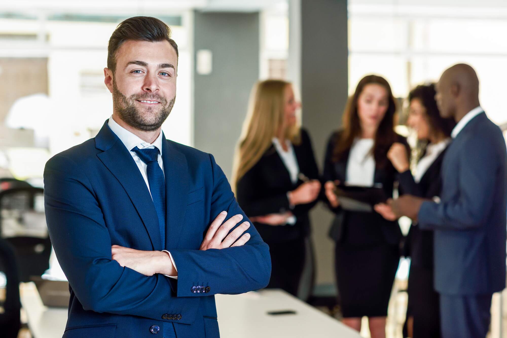An entrepreneur in an office with employees in his background